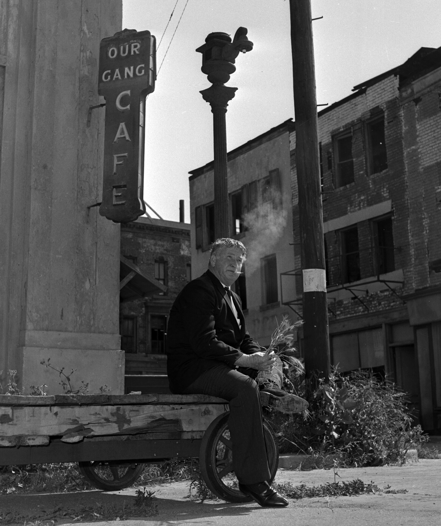 Our Gang Cafe sign at Hal Roach Studios, with actor Chill Wills seated beneath it, 1 July 1963.